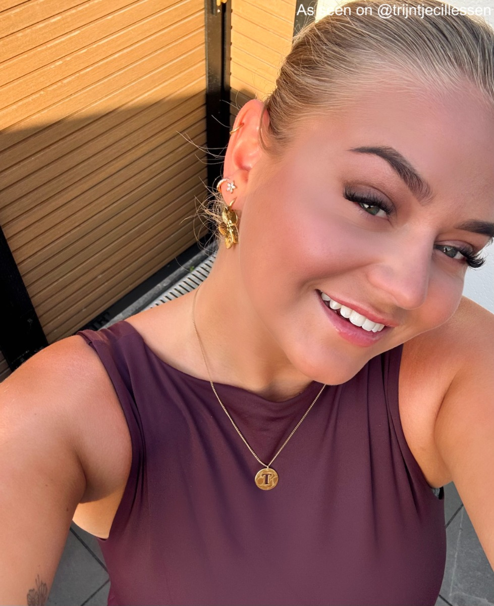 Influencer draagt goudkleurige bloem oorknopjes
