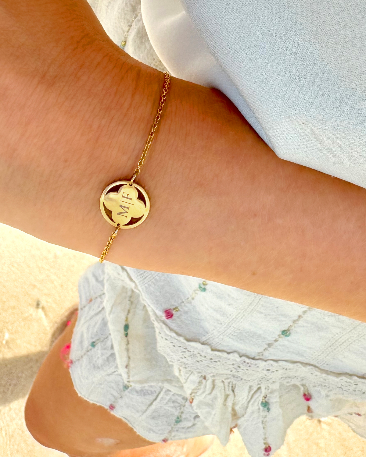 Model draagt gouden clover armband met gravering