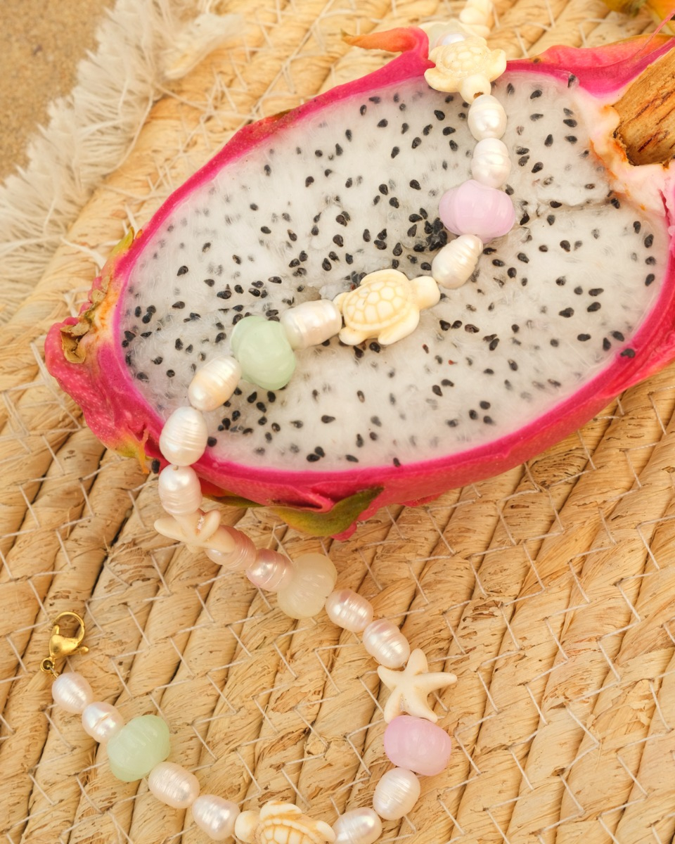 parelketting met pastel bedeltjes op stuk fruit