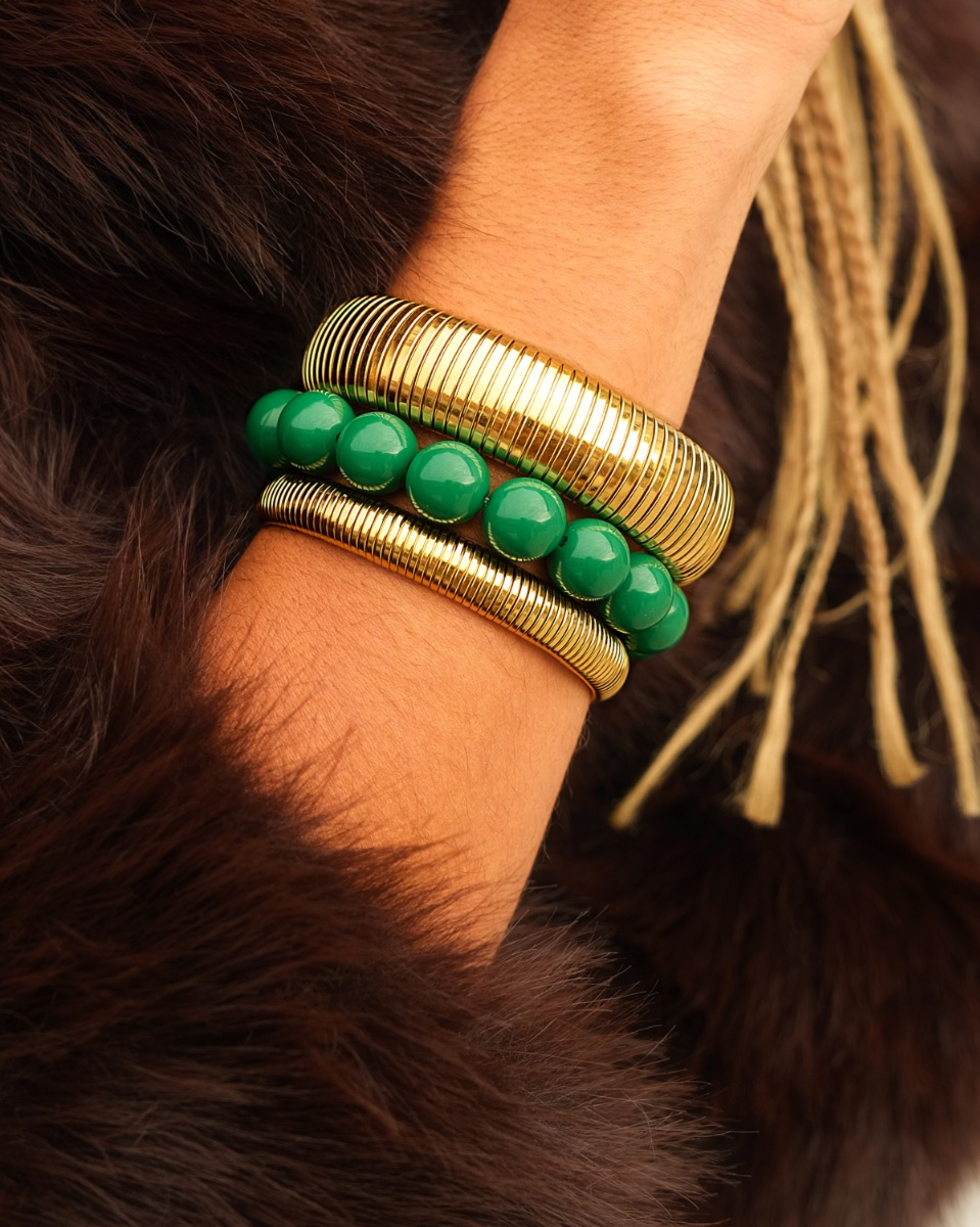 gouden armparty met bangles en groene kralenarmband