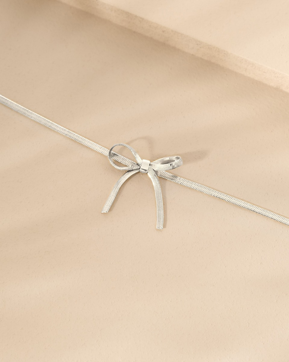 Zilveren armband met strikje op stenen ondergrond