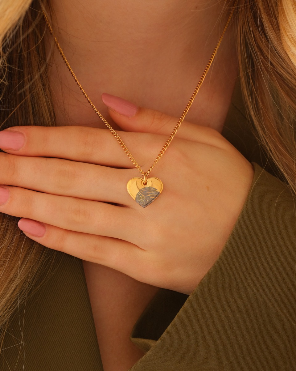 gouden hartjes ketting met vingerafdruk op hand