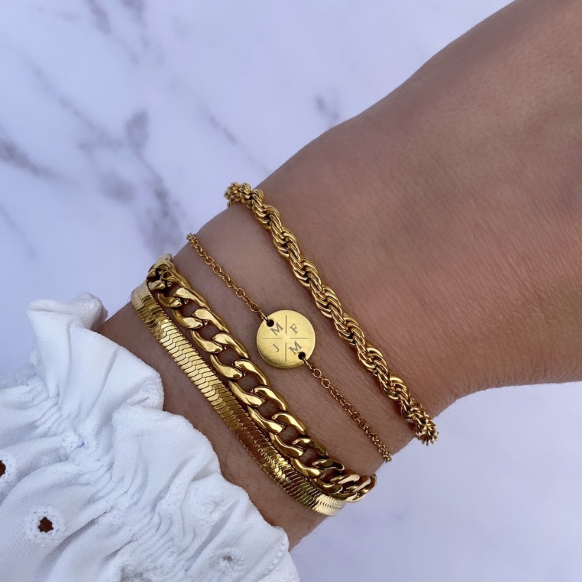 Vrouw draagt mix van gouden armbanden om pols