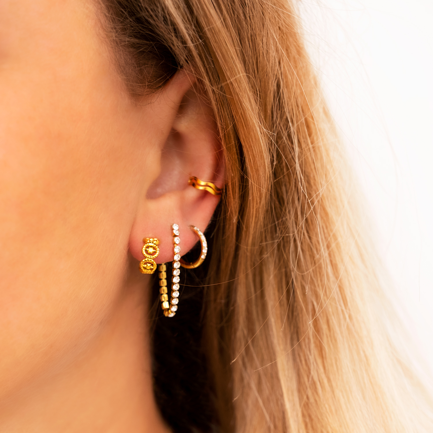 Model draagt earparty met mooie gouden oorbellen