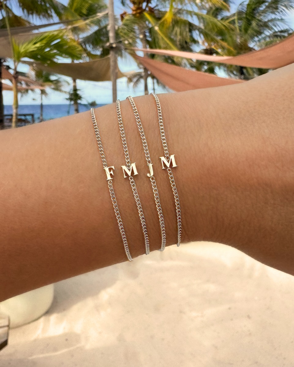 zilveren initial armbandjes combinatie op het strand