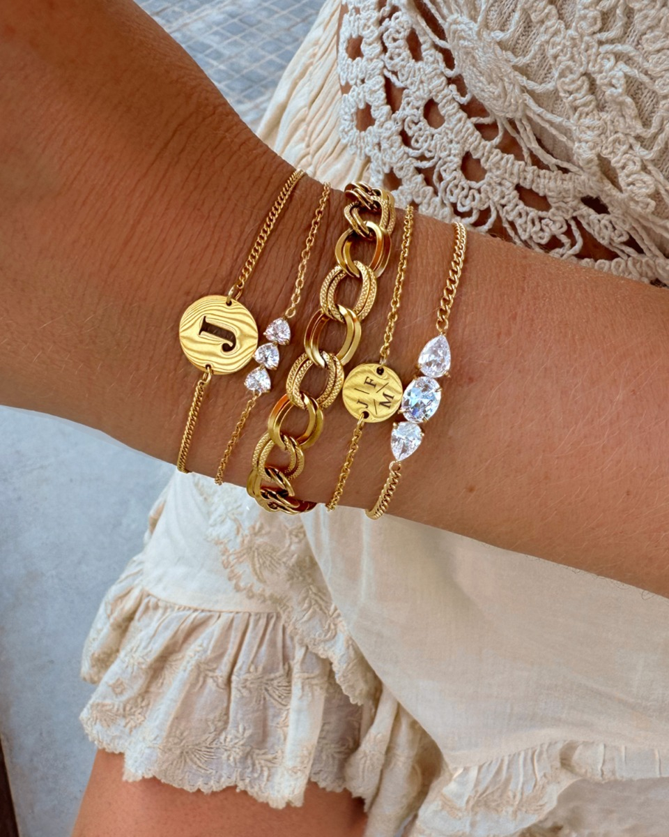 gouden armparty met initials en steentjes