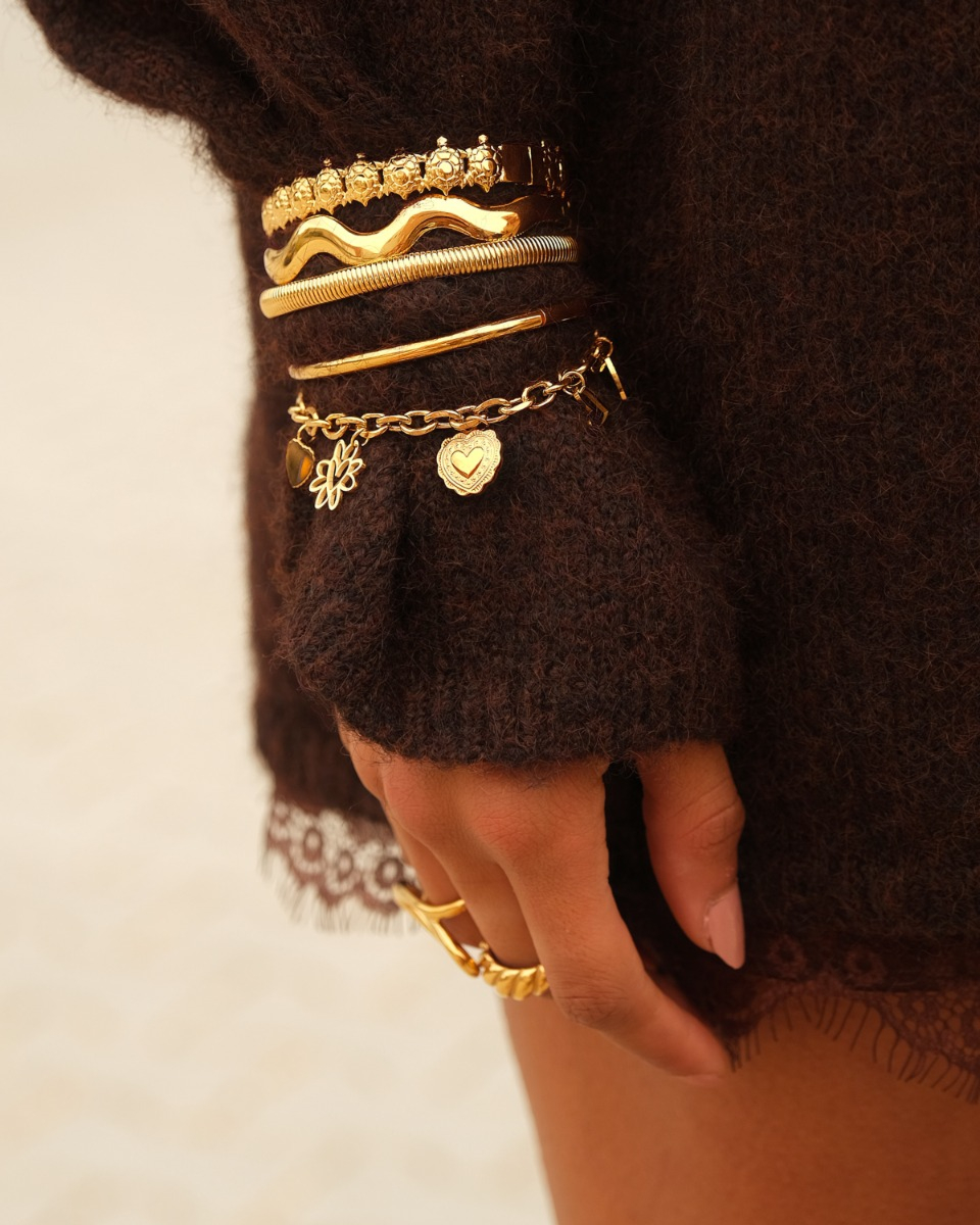Gouden bangles om pols