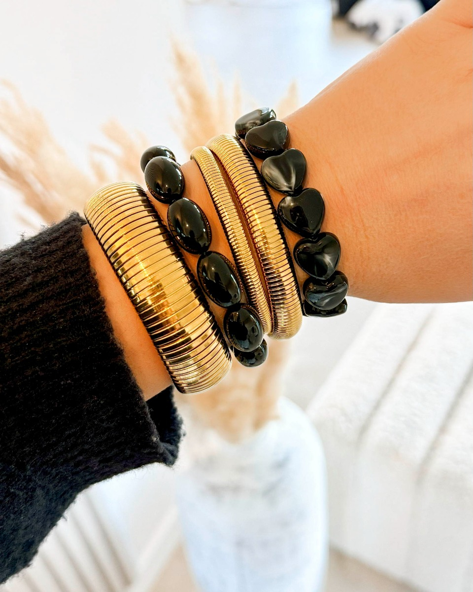 Gouden armparty met zwarte kralen