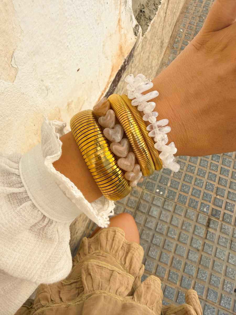 Gouden armparty met bangles en kralen