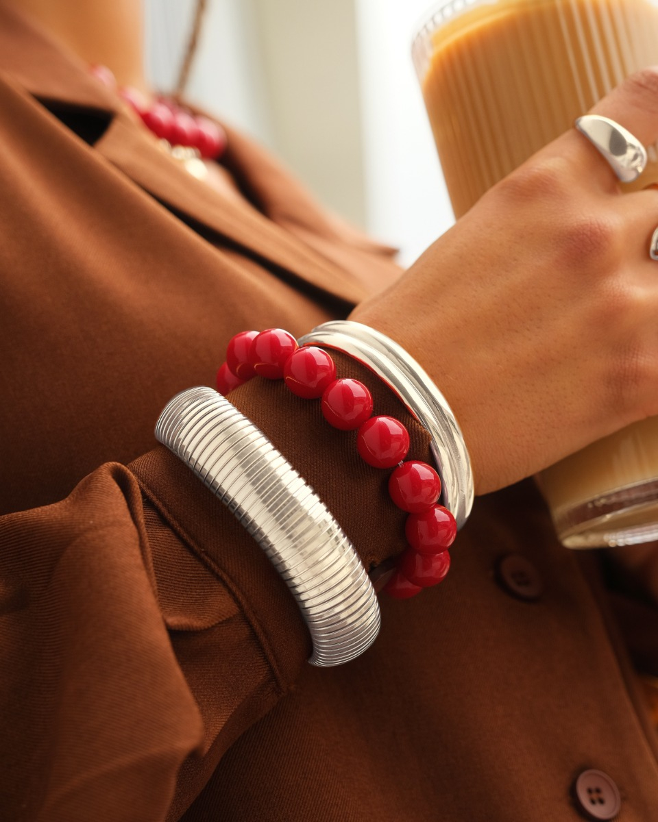 Zilveren armparty met bangles en rode kralen
