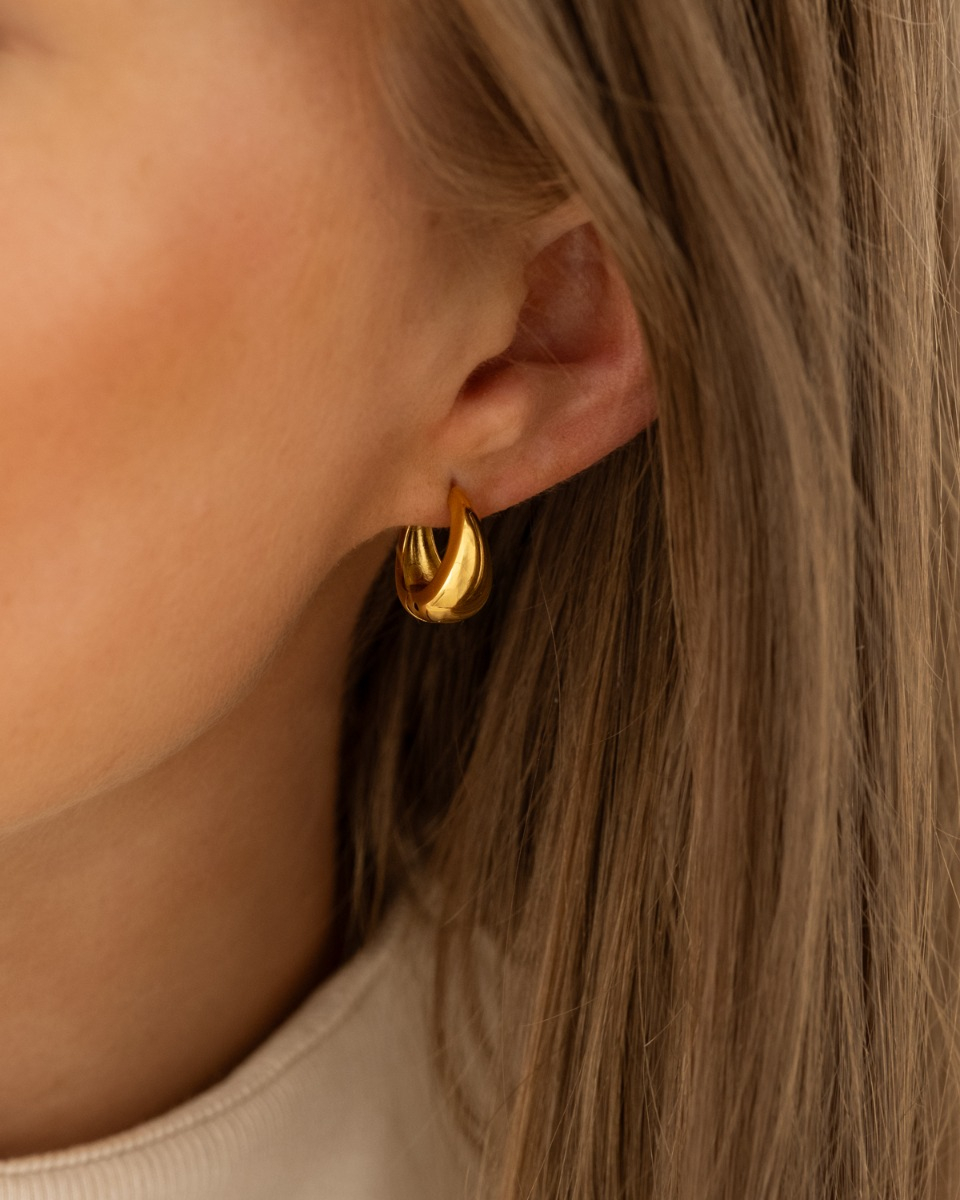 Gouden mini teardrop hoops bij model