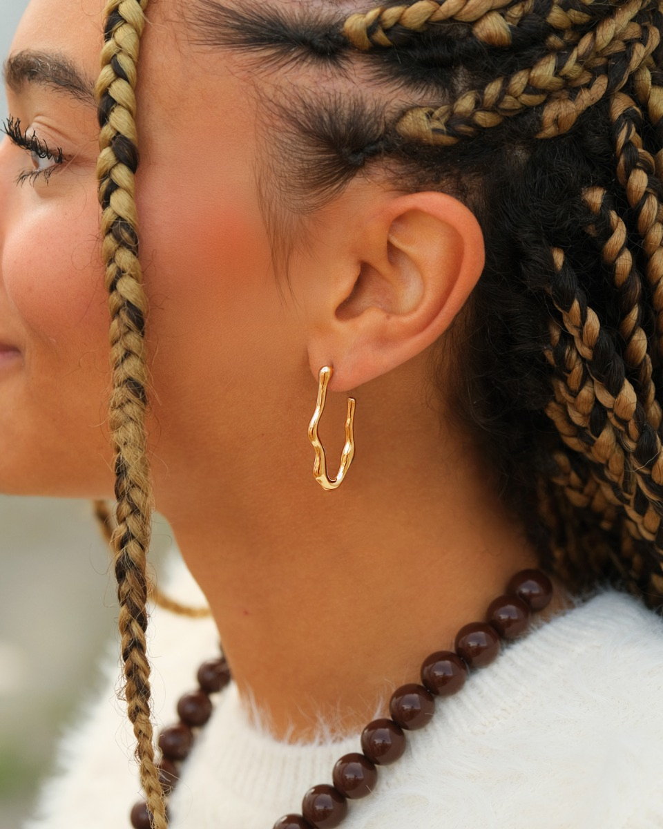 gouden wave hoops bij meisje met bruin haar