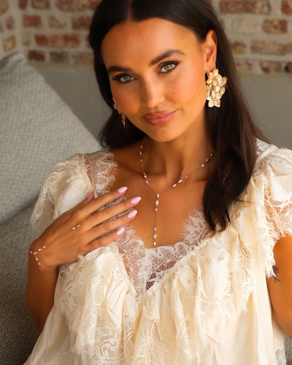 Model draagt gouden sieraden met steentjes