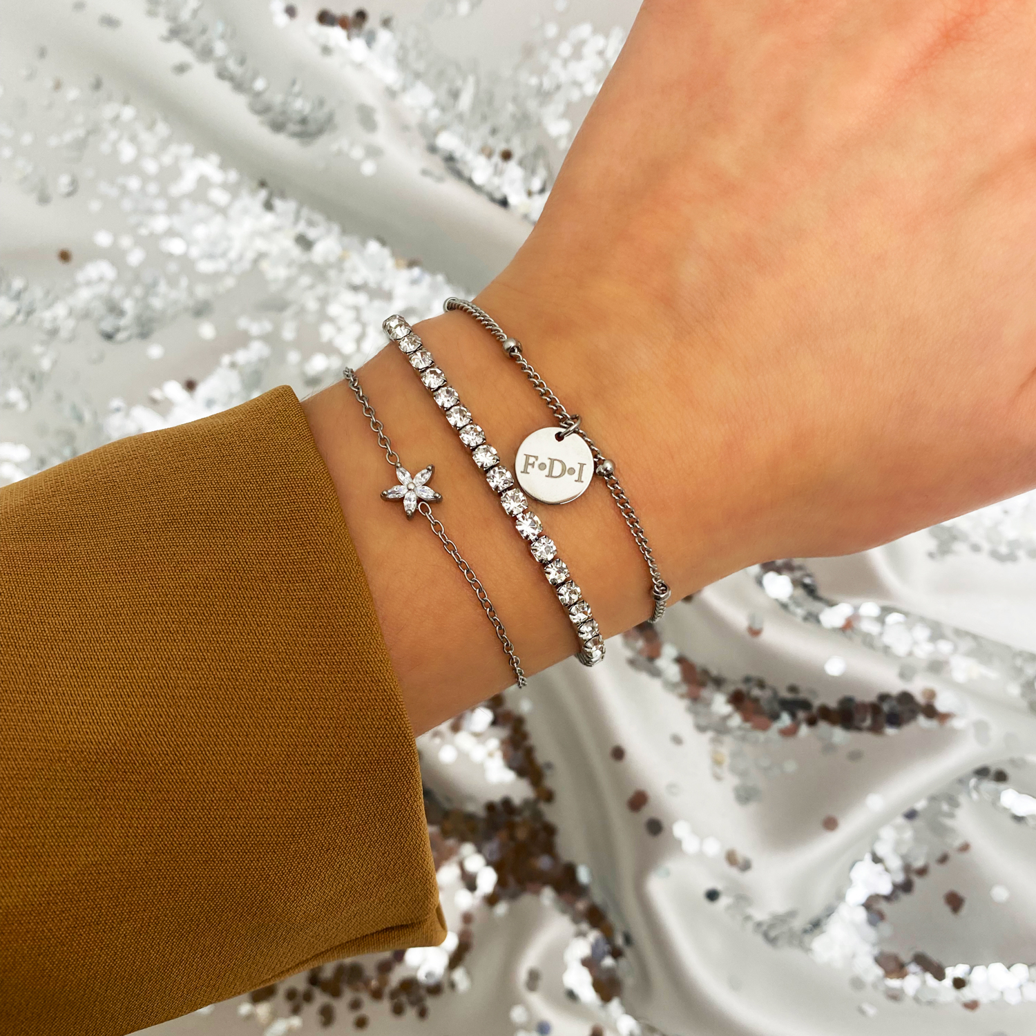 zilveren armparty met tennis armband om pols