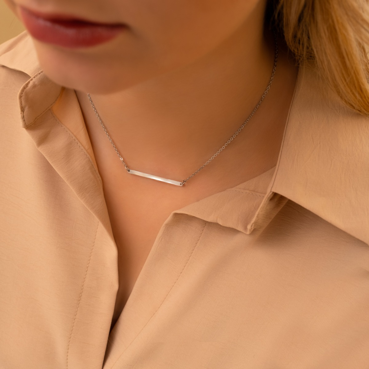Model draagt zilveren minimalistische bar ketting