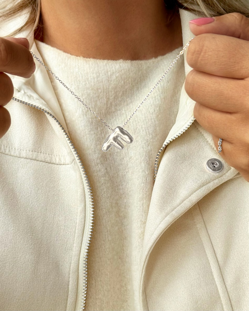 Zilveren letter ketting bij model