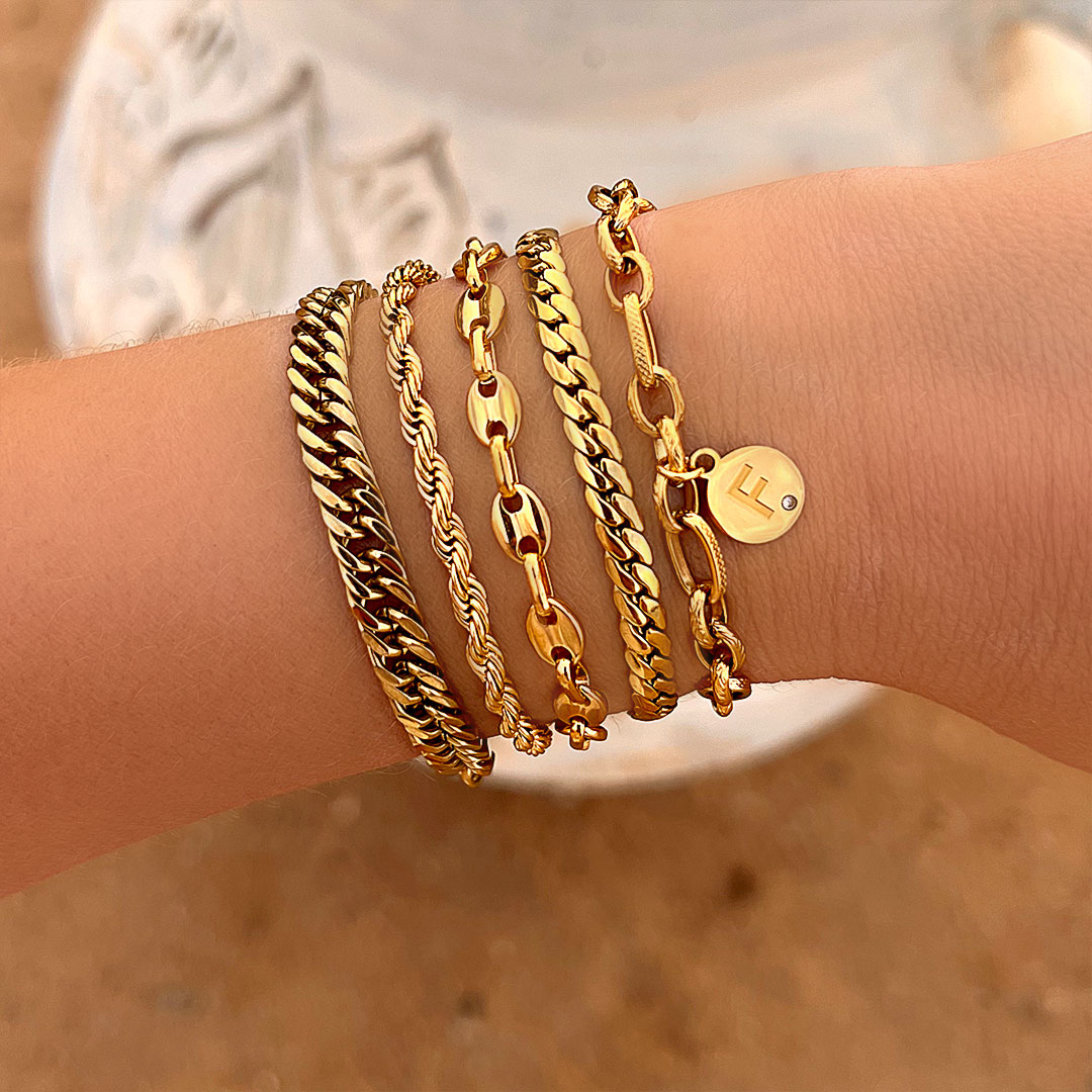 Gouden schakelarmbanden om pols
