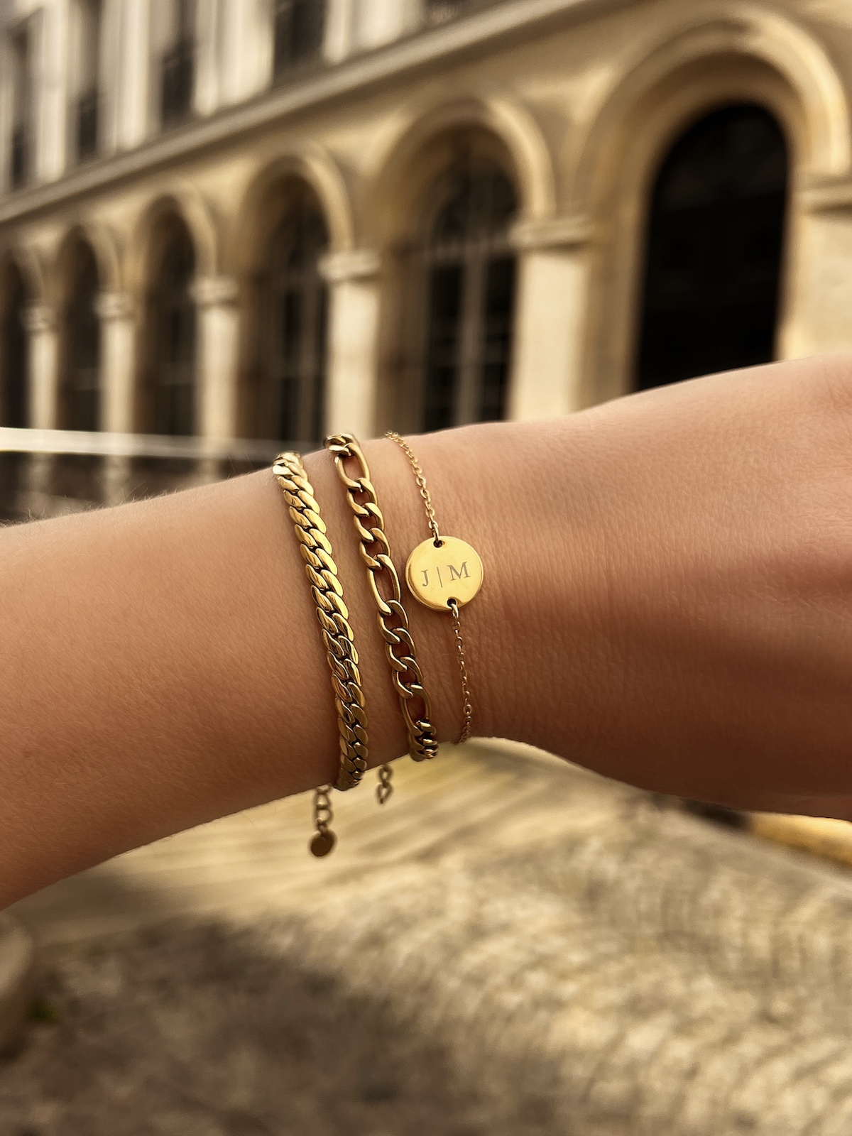 Model draagt gouden armbanden mix