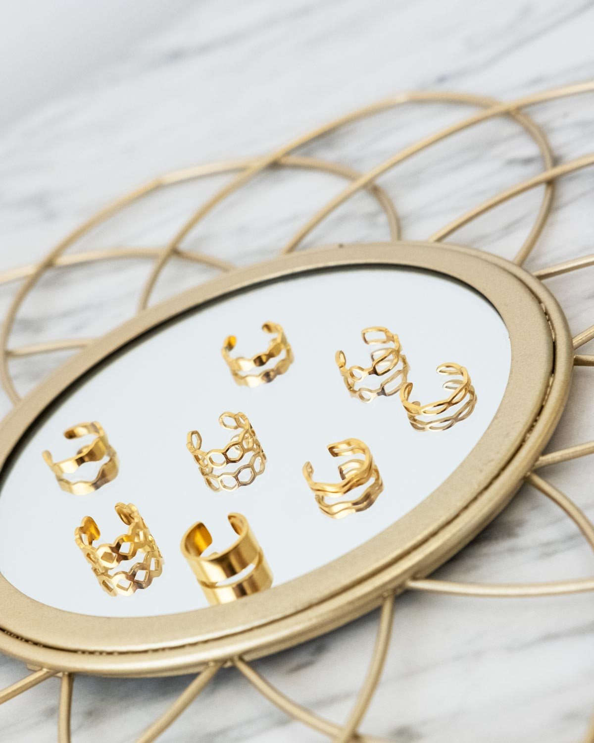 Gouden ear cuffs op een spiegel