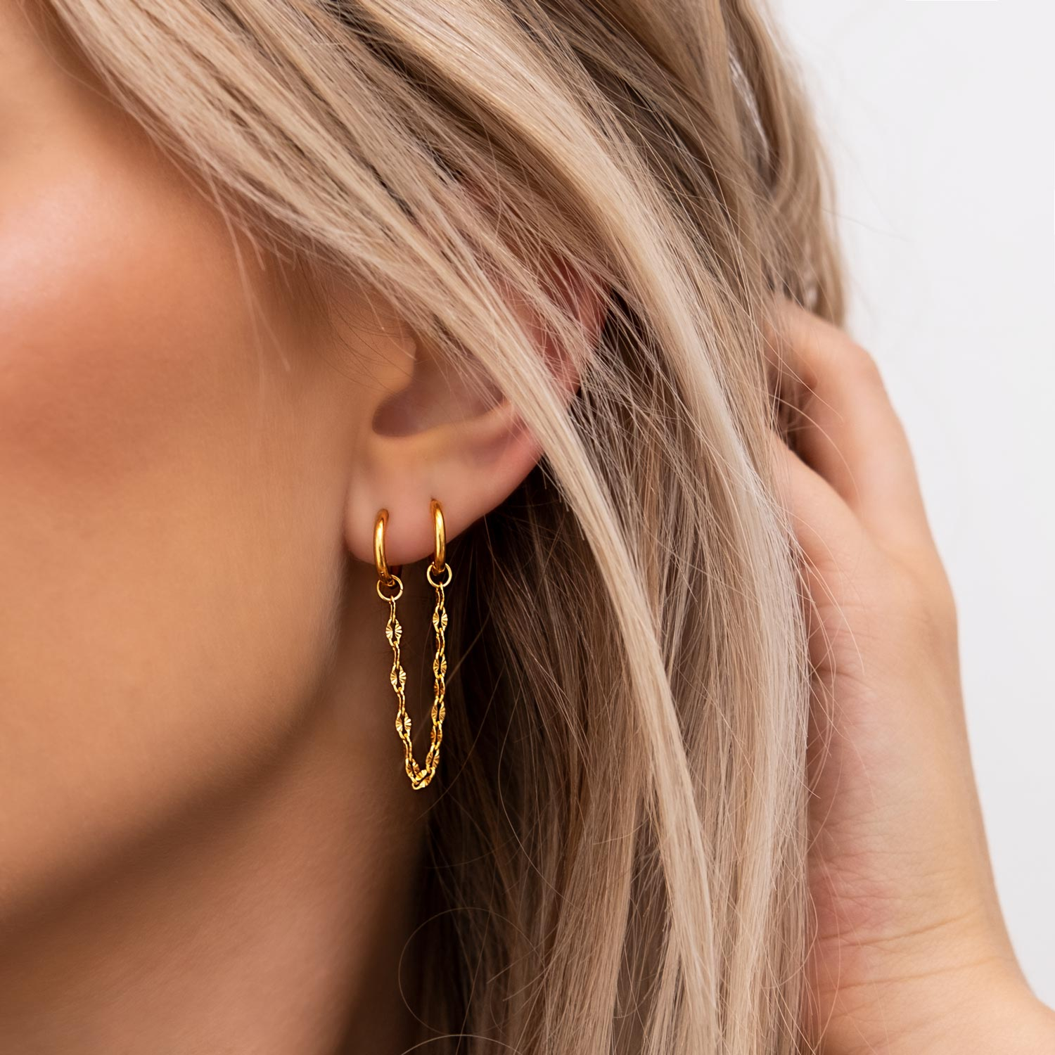 Mooie gouden double hoop oorbellen in het goud in het oor