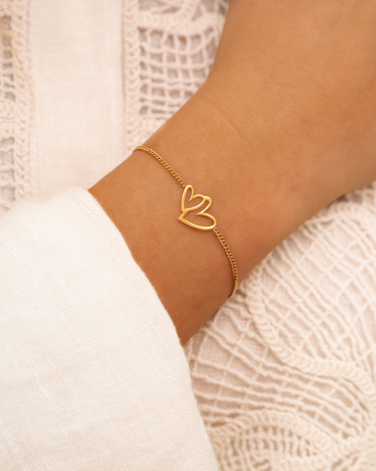 Model draagt gouden hartjes armband