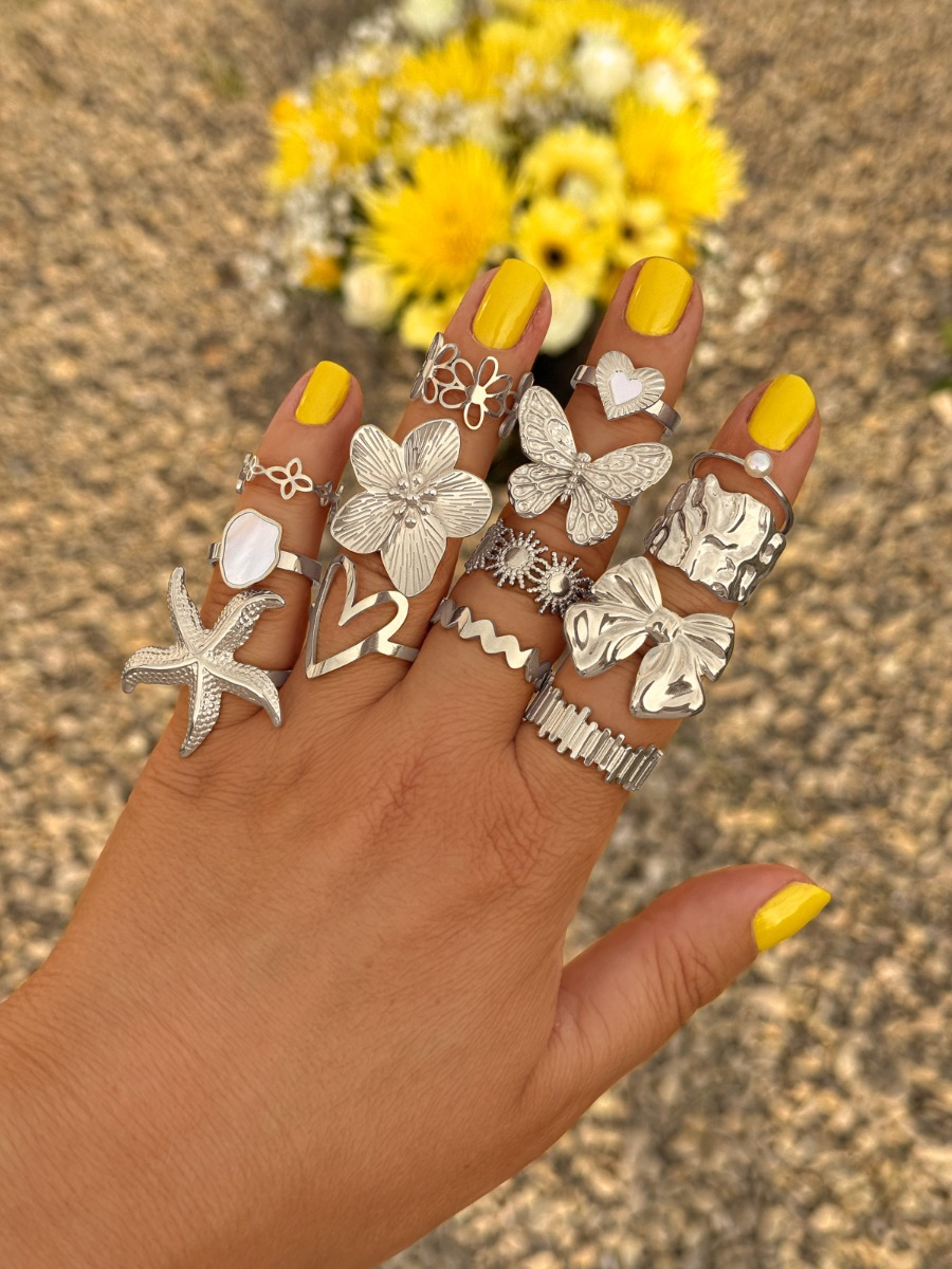 zilveren ringen mix met gele bloemen op de achtergrond