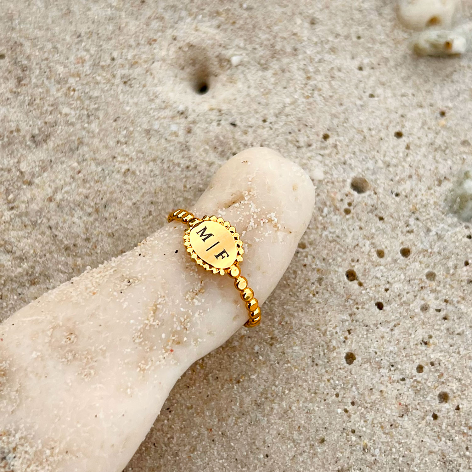 Mooie gouden vintage ring met initialen op strand