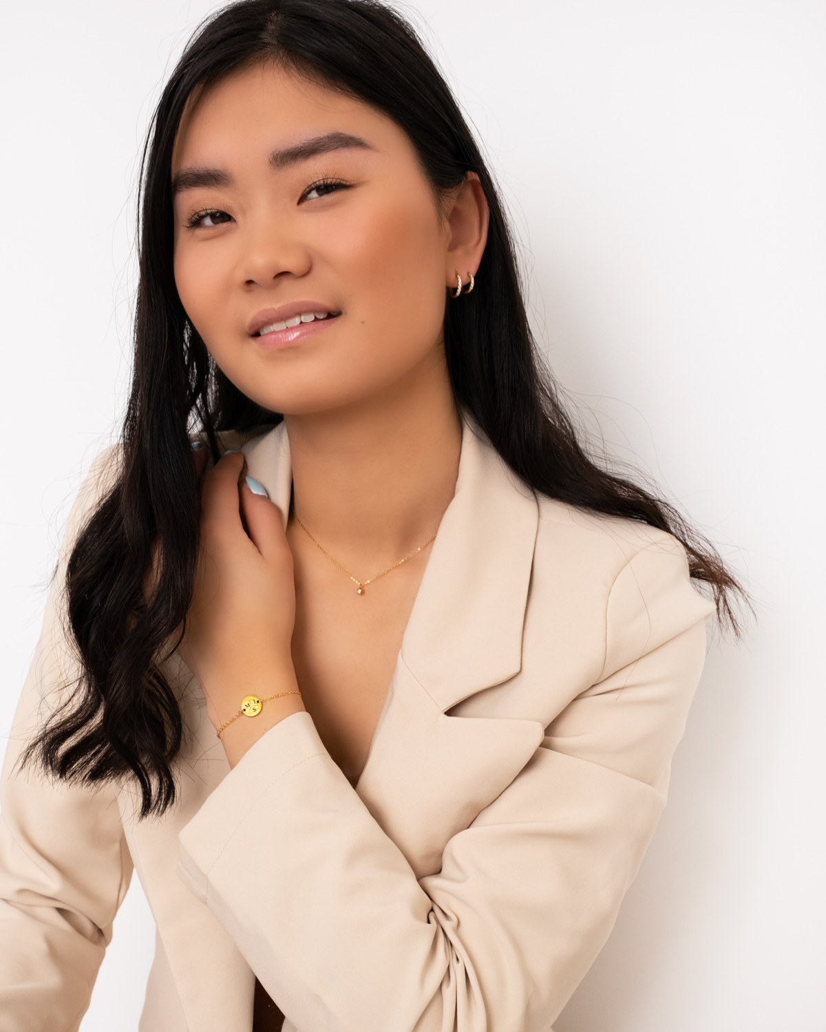 Model draagt gouden sieraden met steentjes
