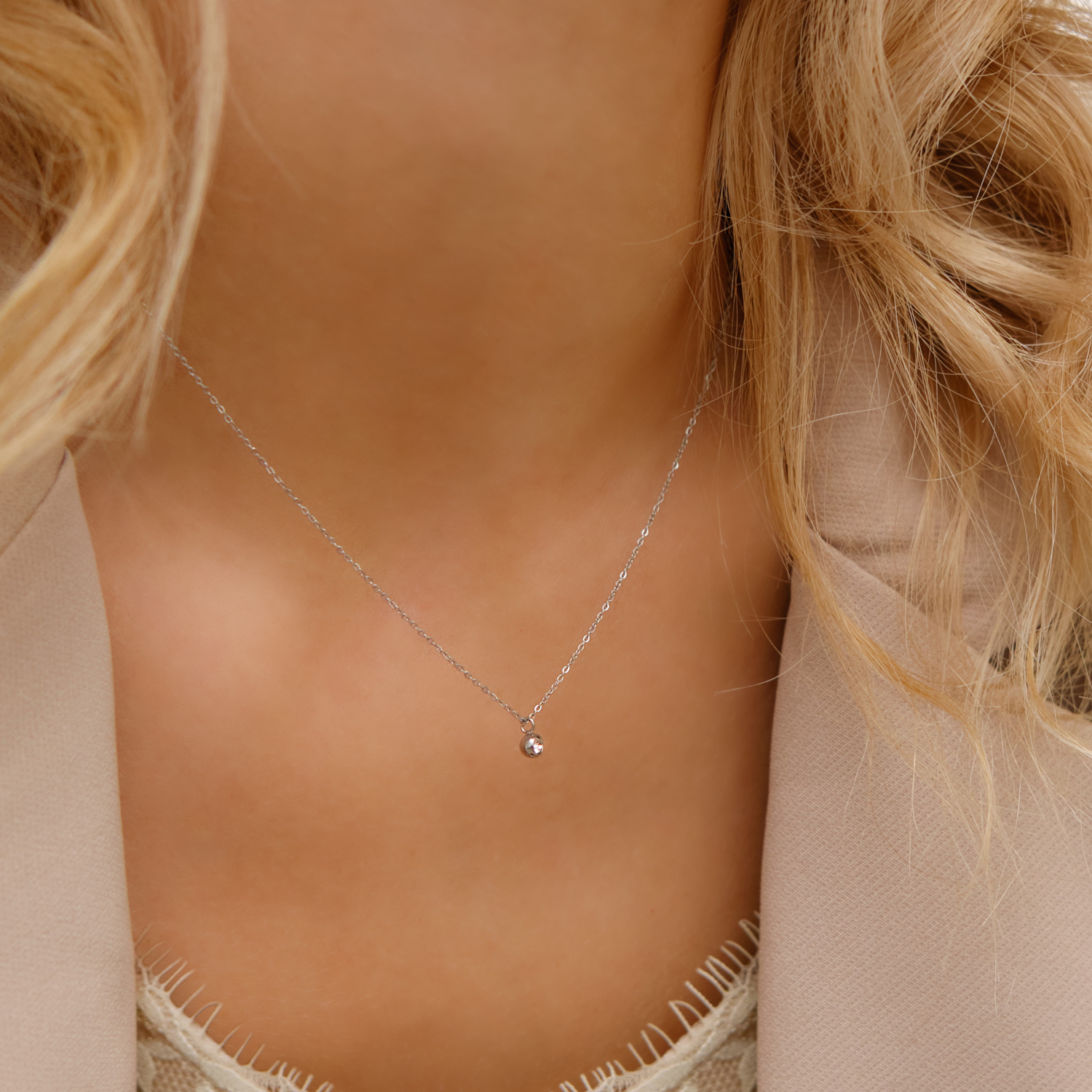 Model draagt zilveren ketting met steentje