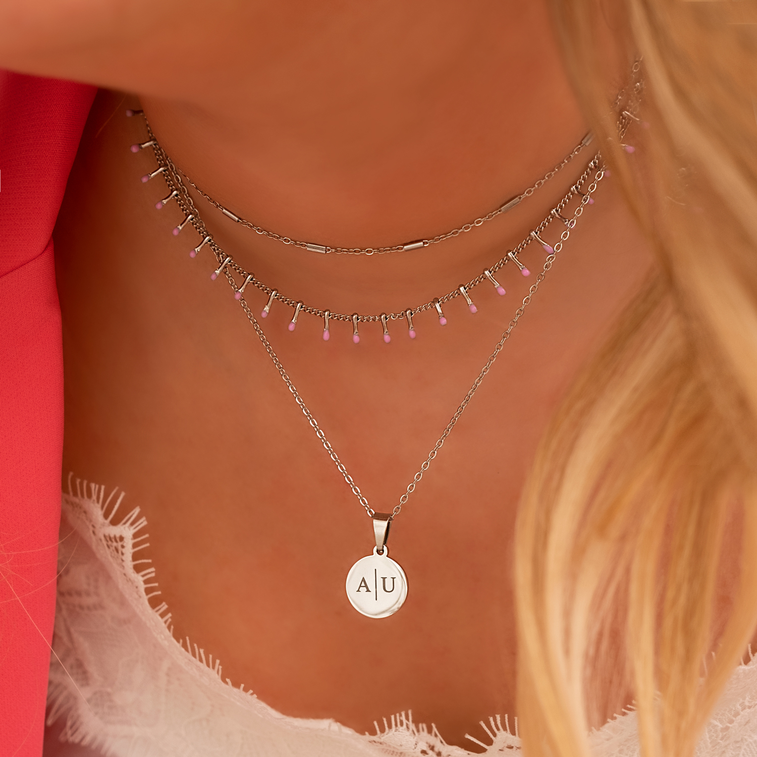 Model draagt necklace layer met zilveren kettingen