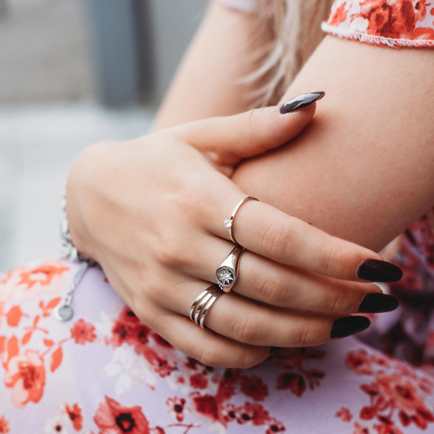 Model draagt mix van zilveren ringen om hand