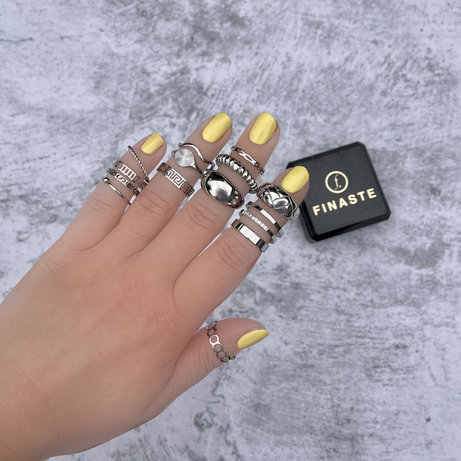 Het model draagt een ringen mix van zilveren sieraden met sieradendoosje