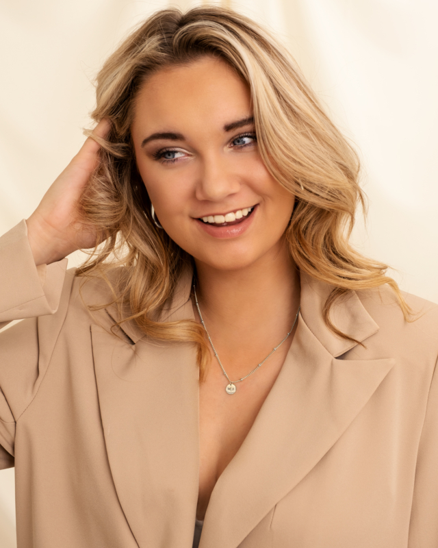 model draagt zilveren ketting met muntje 