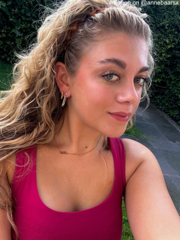 Influencer draagt gouden ketting met drie hartjes