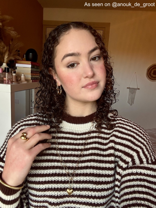 Influencer met gouden lange ketting met hart hangertje