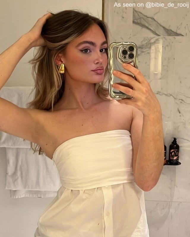 Influencer met gouden oorbellen.