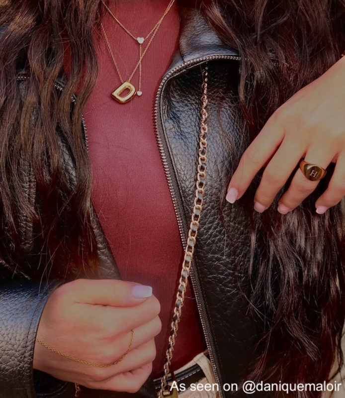 Influencer draagt gouden ketting met initiaal