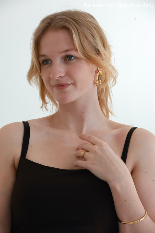 Influencer met gouden oorbellen, ring en bangle