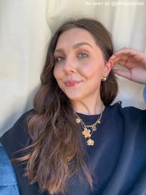 Influencer draagt gouden stud oorbellen bloem met parel