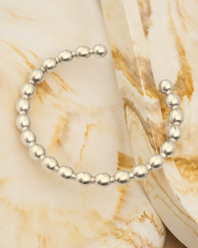 zilveren bolletjes bangle op marmeren ondergrond