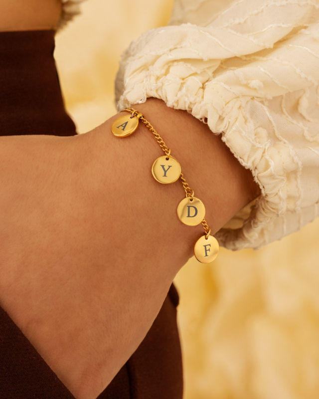 Gouden muntjes armband om pols