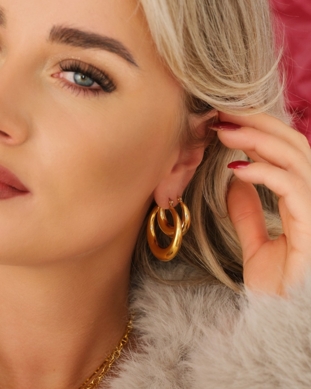 Model draagt oorbellen set goud
