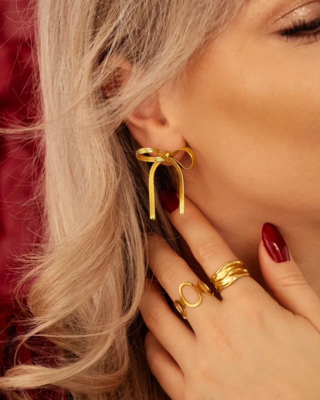 Gouden oorbellen en ringen mix bij model