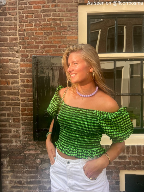 Vrouw draagt paarse parelketting
