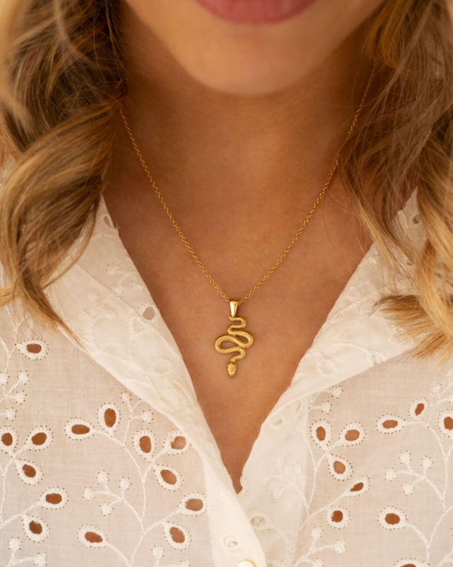 Model draagt ketting met slang in goudkleurig