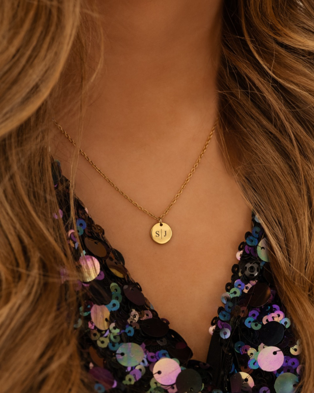 Gouden initialen ketting met muntje bij model