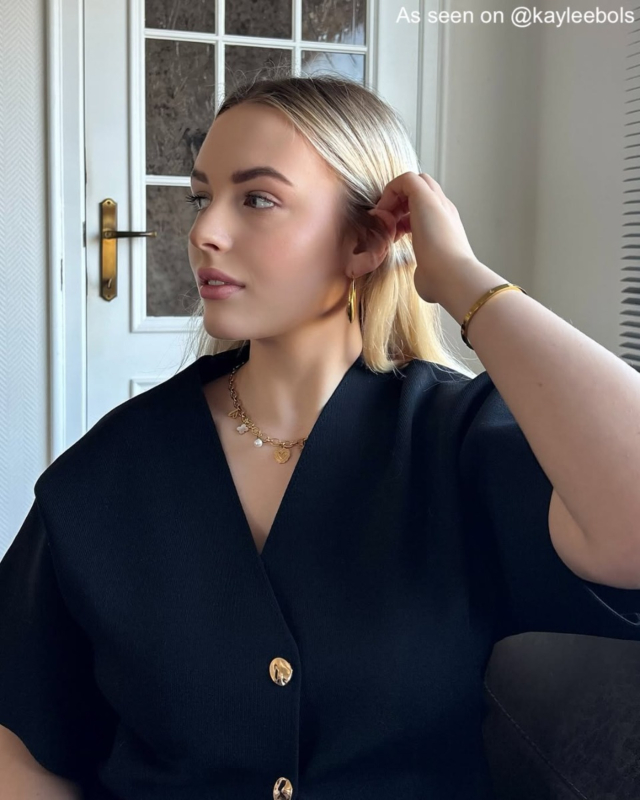 Influencer met gouden hoops, bangle en statement ketting