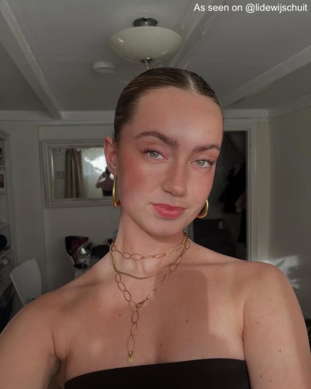 Influencer met goudkleurige ketting.