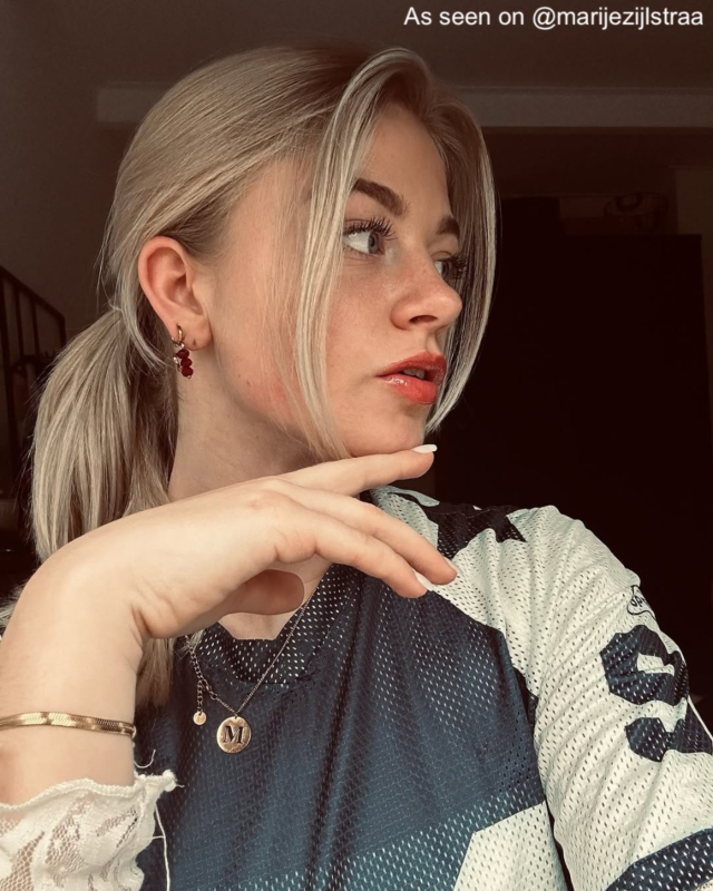 Influencer met gouden oorbellen en initial ketting