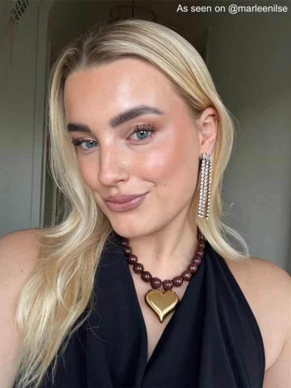 influencer draagt bruine kralen ketting groot goudkleurig hart